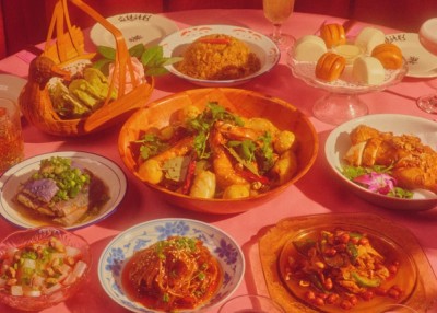 A round table with a pink tablecloth and a variety of dishes