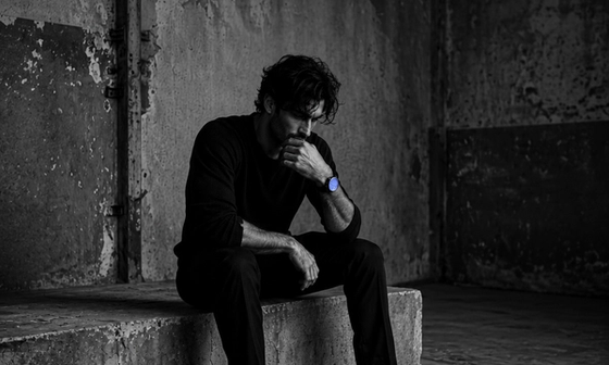 Man sitting alone at night showing the emotional signs of betrayal trauma after infidelity.