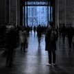 Man standing motionless in a blurred, moving crowd, illustrating the isolation emotional support is meant to address