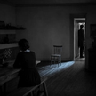 Two partners alone in a dark room, turned away from each other, illustrating how long it takes to get over an affair.