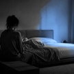Woman sitting alone at night on the edge of a bed, one side untouched, illustrating the isolation behind why women cheat