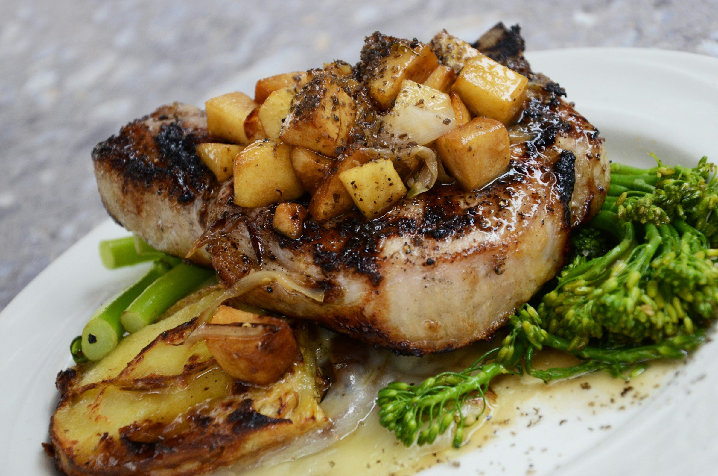 Côte de porc grillée, dés de pomme poêlés, pommes de terre et brocolis