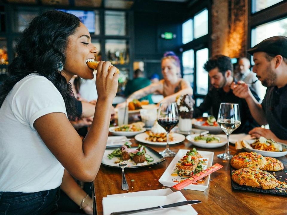 Tablée d’amis partageant un repas convivial dans une salle animée