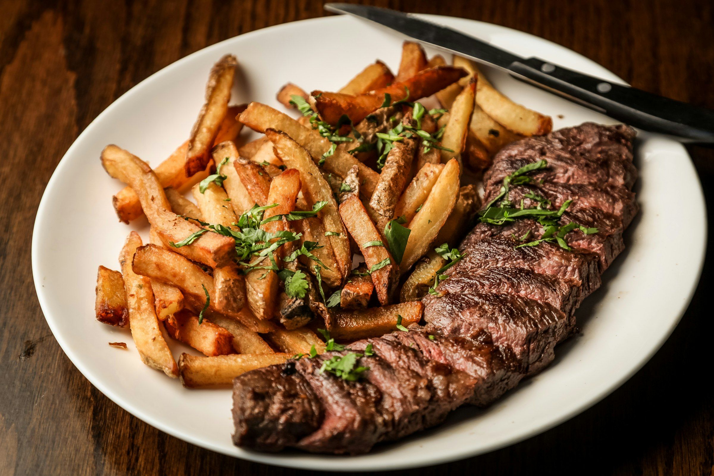 Pièce de bœuf tranchée servie avec des frites maison