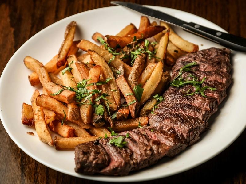Pièce de bœuf tranchée servie avec des frites maison
