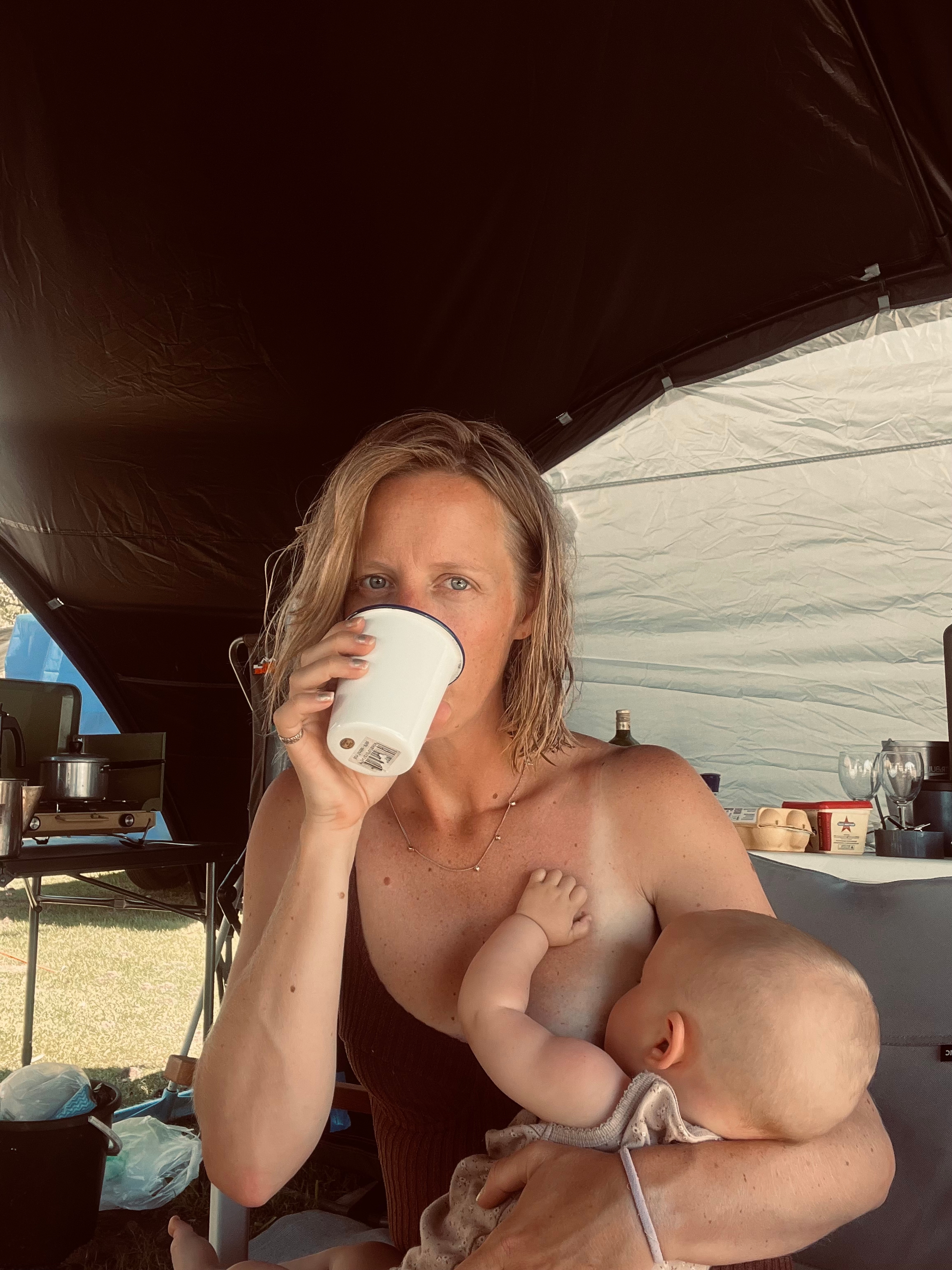 Sally Smith holding her baby and a coffee.