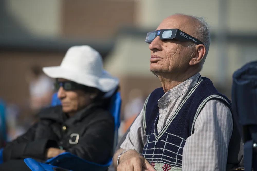 La observación segura del eclipse requiere gafas homologadas y supervisión, especialmente en niños. Personas observando un eclipse solar con gafas homologadas de protección