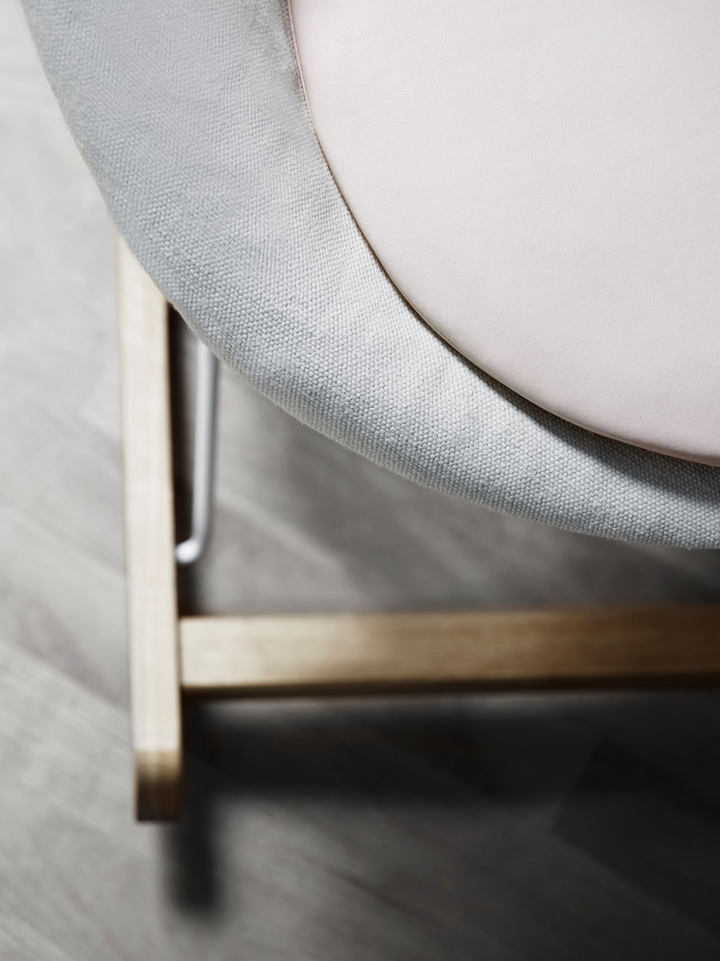 Rocking Nest Chair by Carl Hansen & Søn — a foldable rocking chair in walnut wood with a suspended canvas seat and steel cable details, shown in profile on a white background.