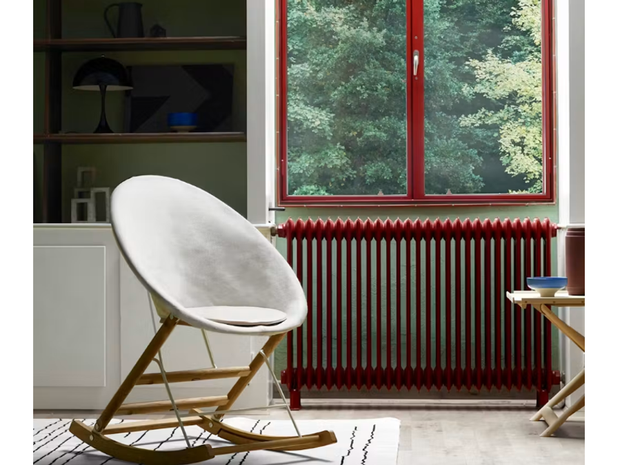 Anker Bak’s rocking chair in a room with a red-framed window, bookcase and patterned rug