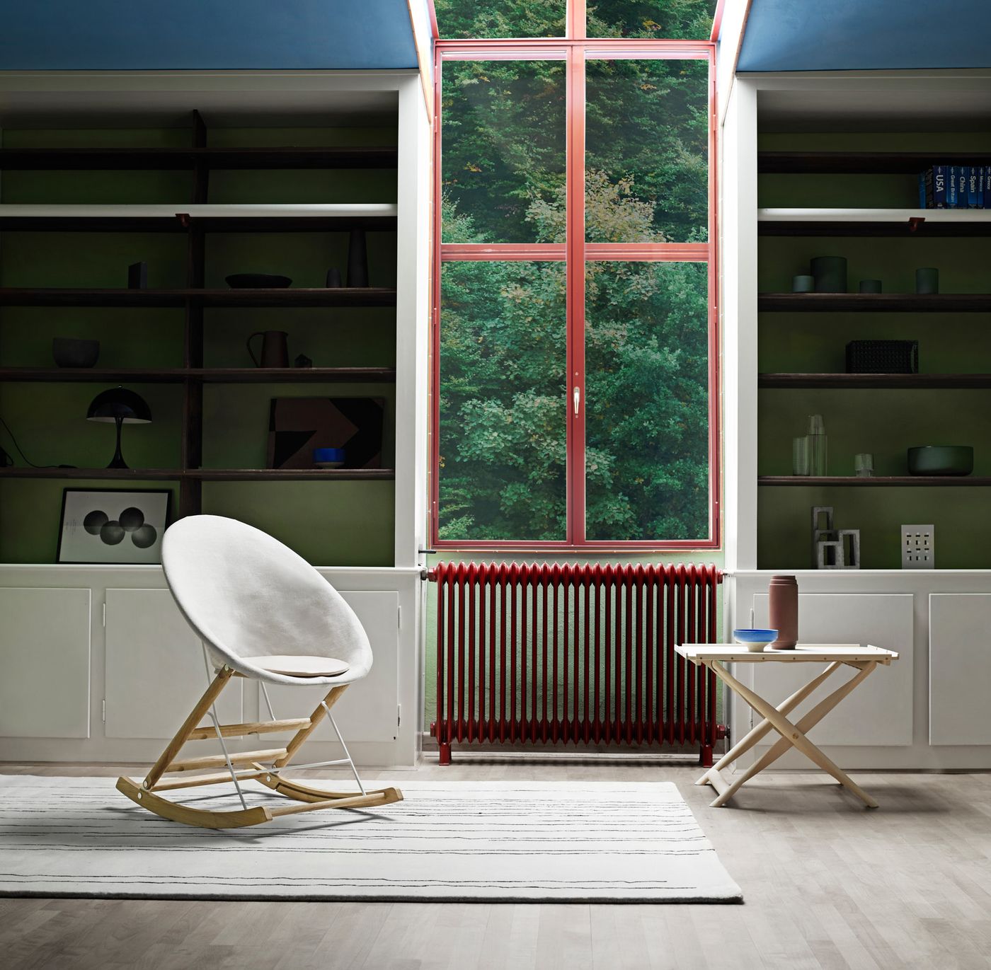 Rocking Nest Chair by Carl Hansen & Søn — a foldable rocking chair in walnut wood with a suspended canvas seat and steel cable details.