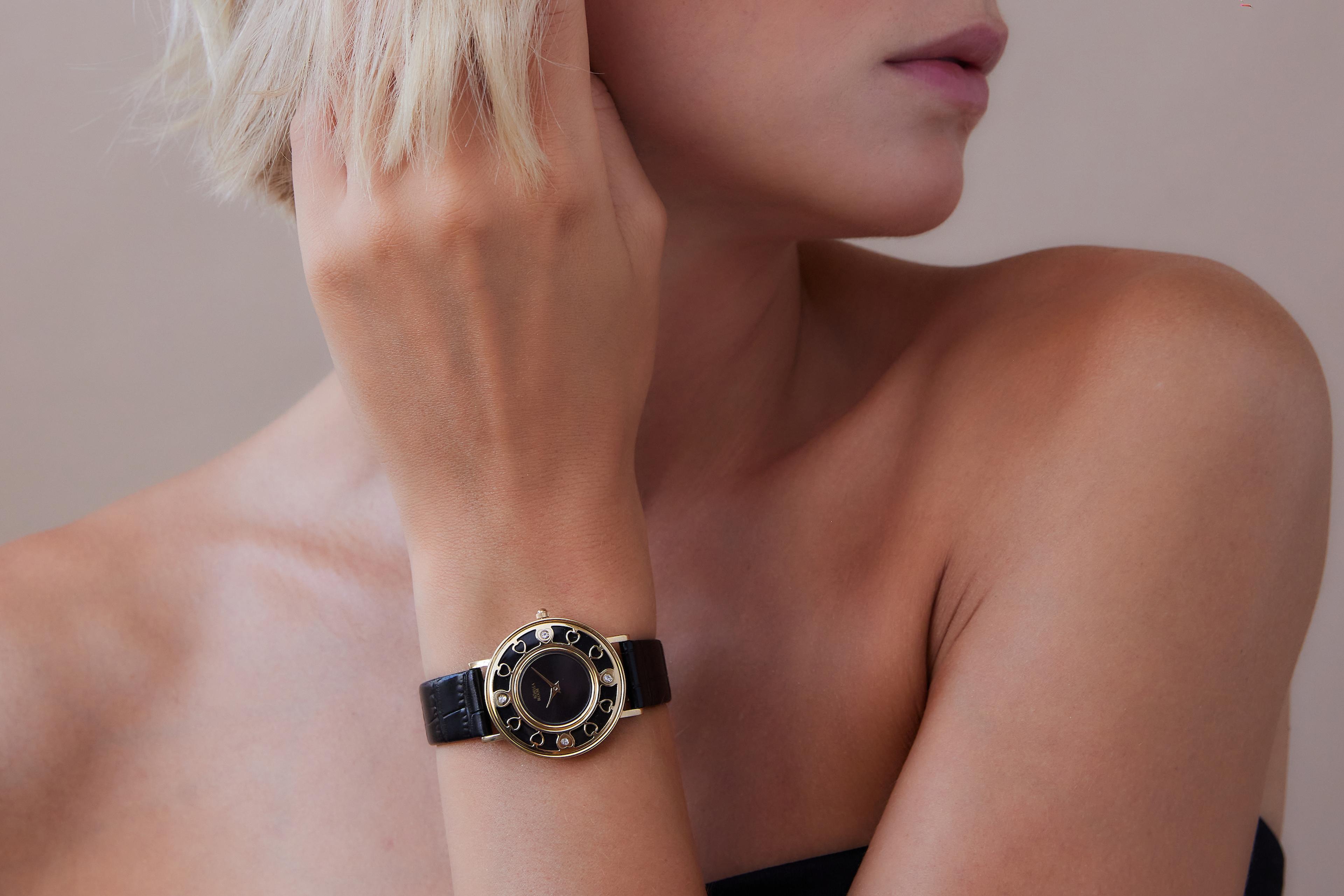 A woman wearing a black and gold Rosella Bloom watch with leather strap.