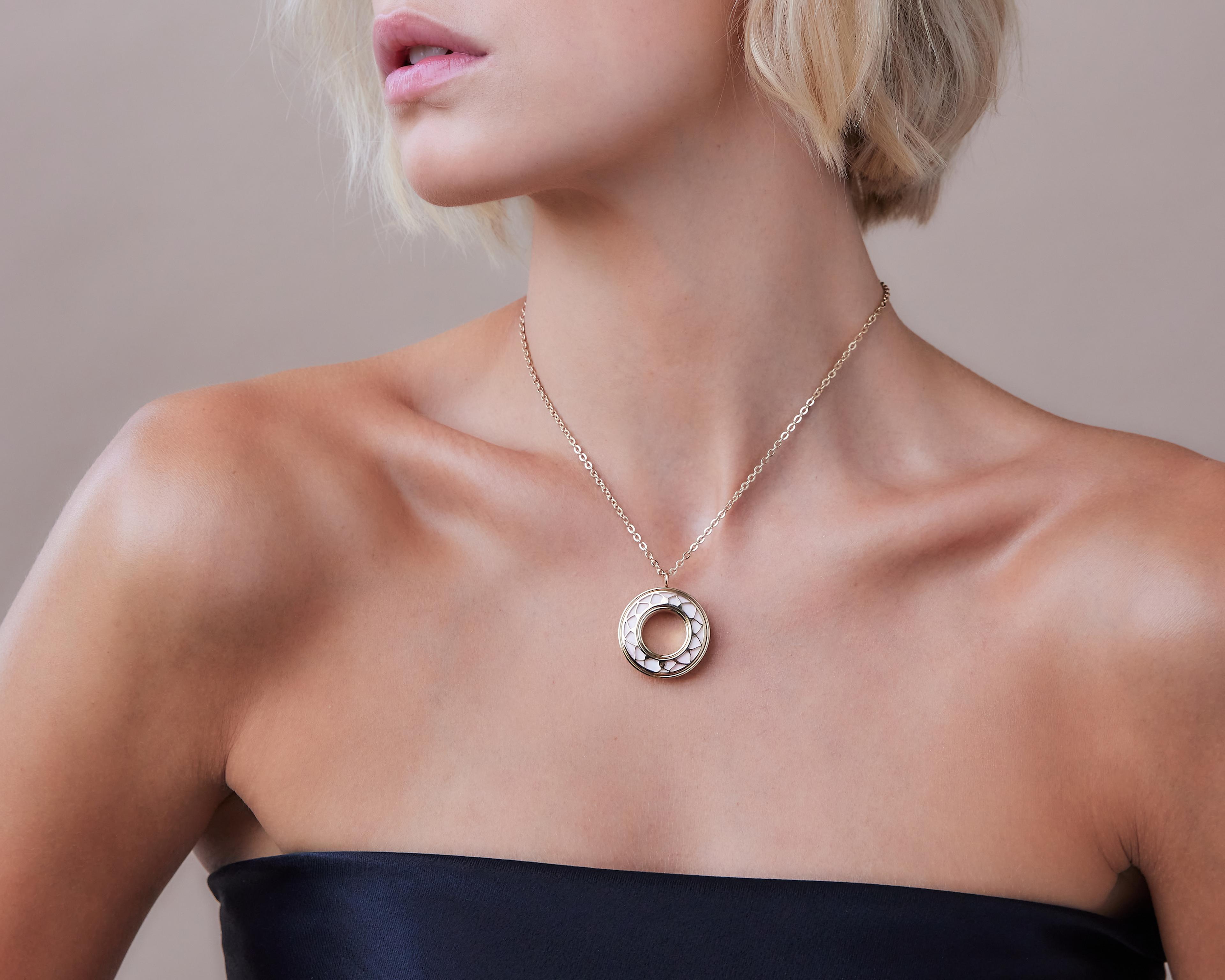 A woman wearing a gold and white Rosella Bloom pendant