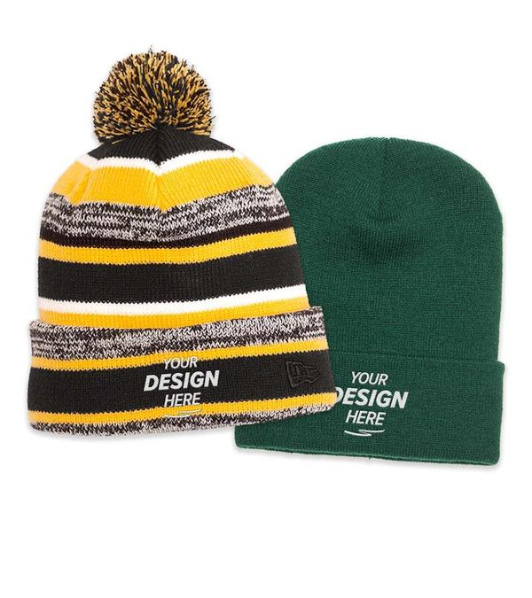 Two knit beanies: one striped with yellow and black pom-pom, the other solid green, both with 'YOUR DESIGN HERE' text embroidered.