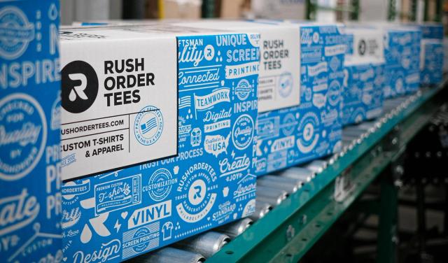 Boxes of custom printed t-shirts on a conveyor belt