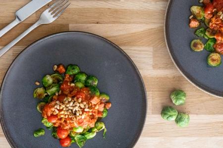 Tomatsovs med salsiccia serveret på stegt rosenkål