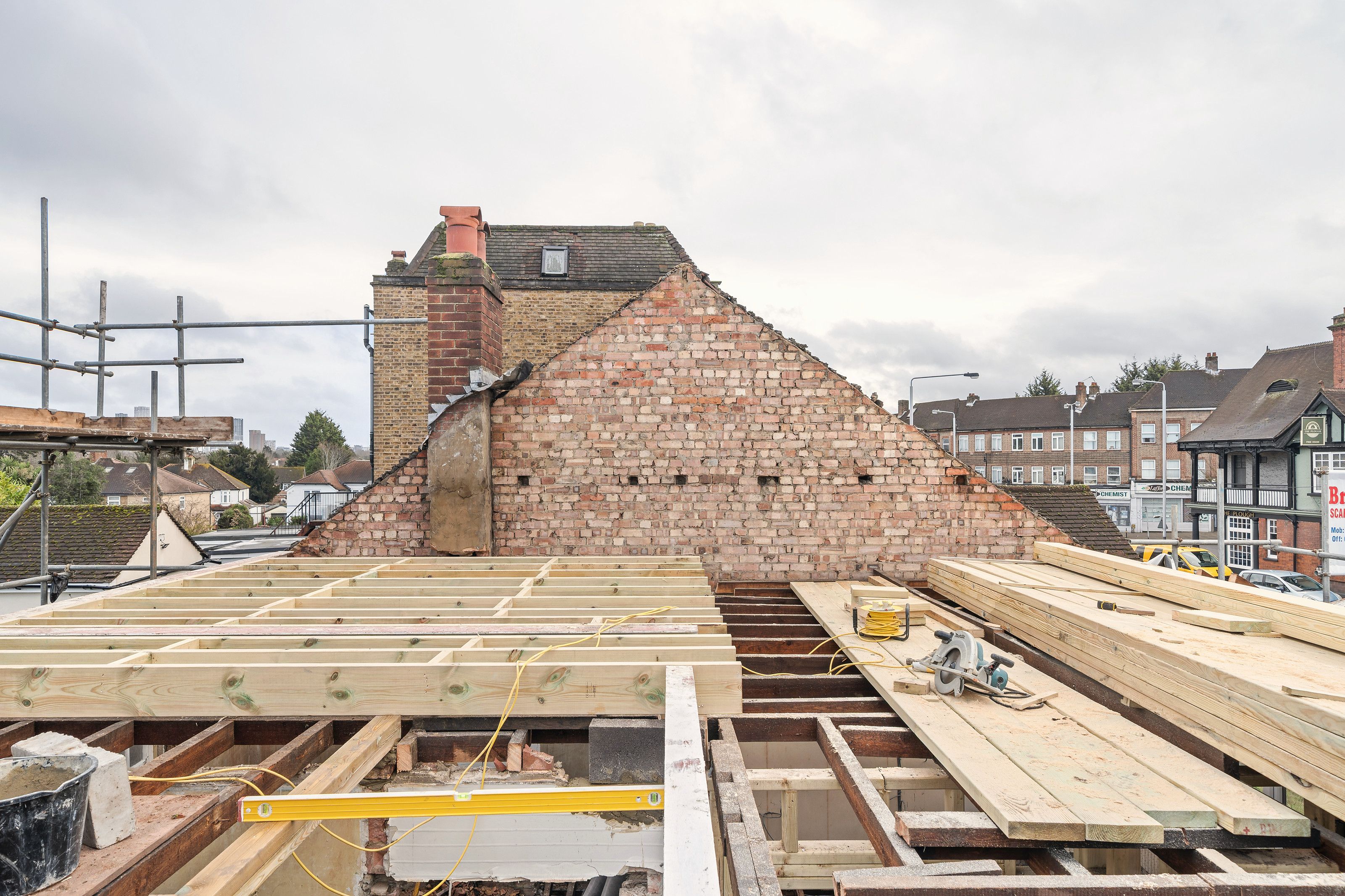 New roof joists laid across the top of the bungalow against the brick gable
