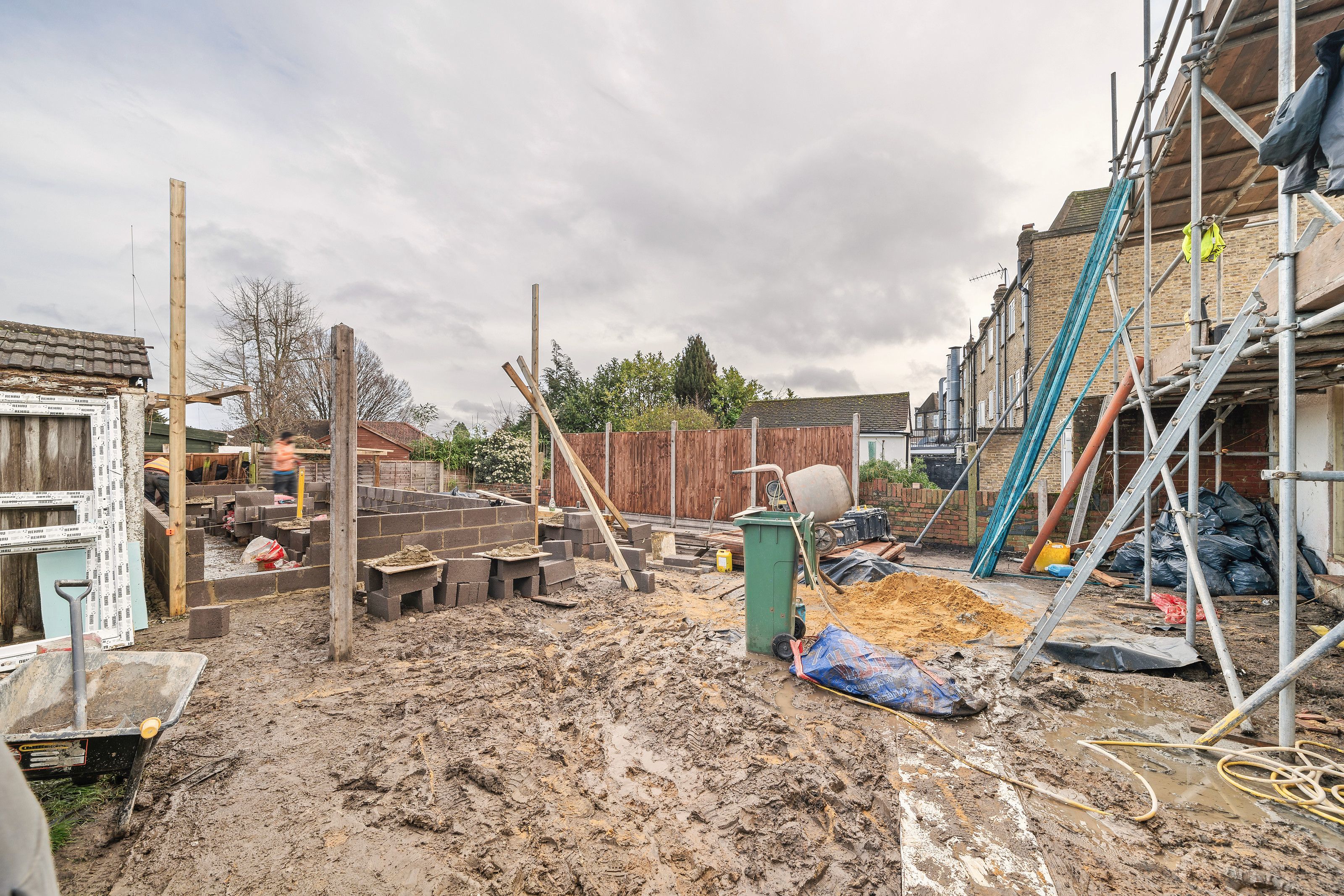 The rear garden with new blockwork walls going up and scaffolding against the house