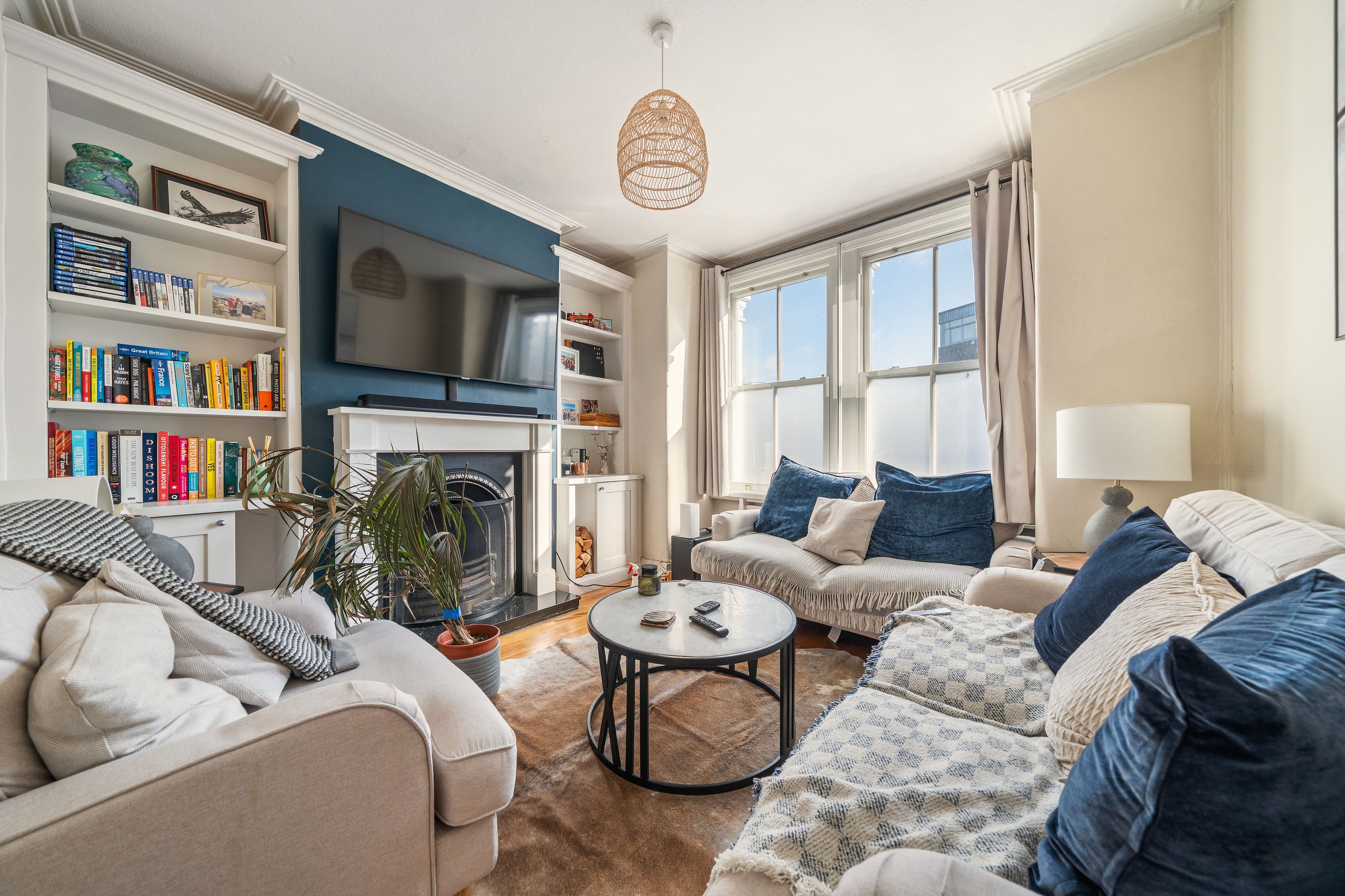The front living room before the work, with fitted shelving either side of the fireplace