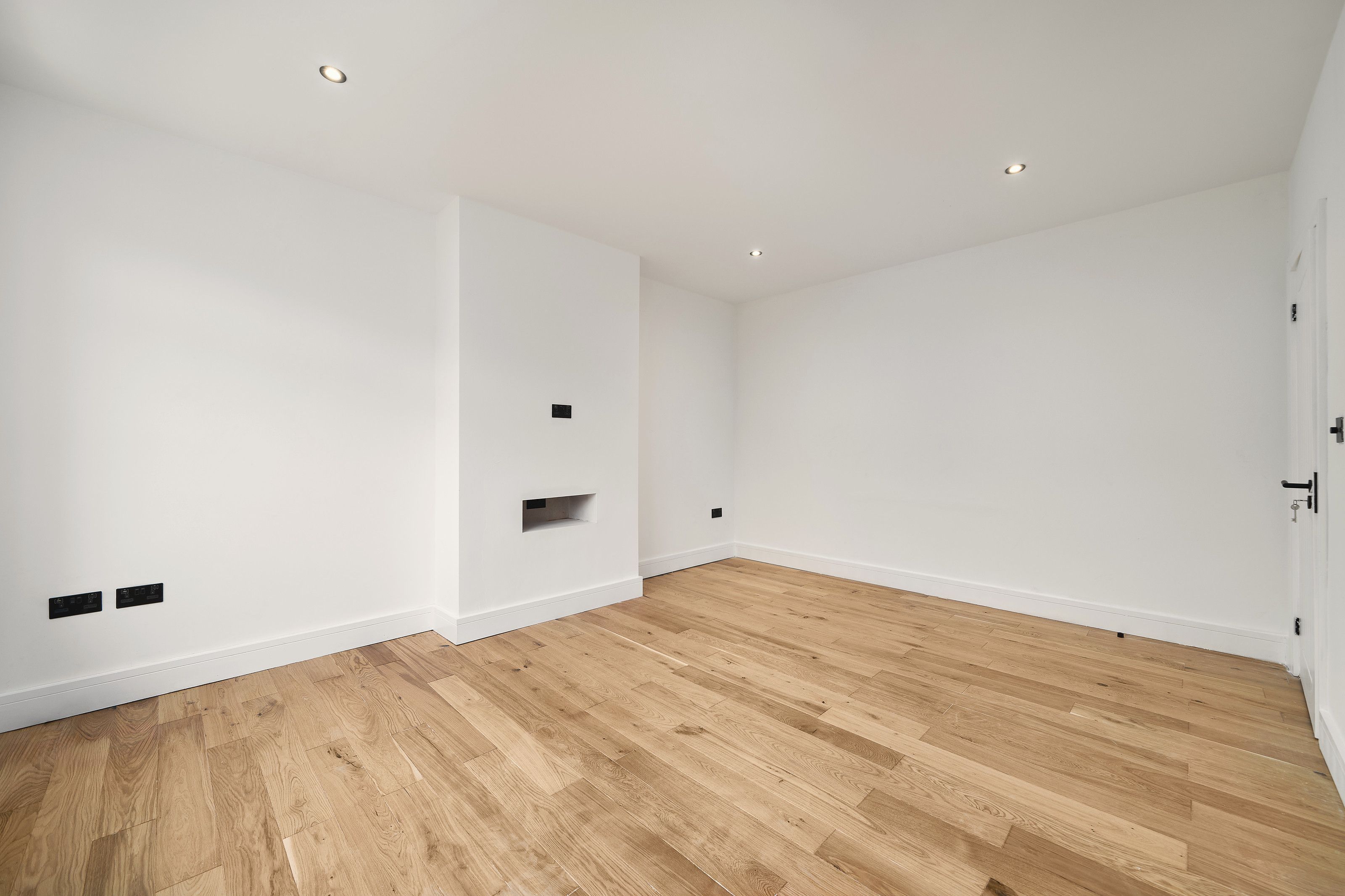 The front room from the other side, white walls and wood flooring