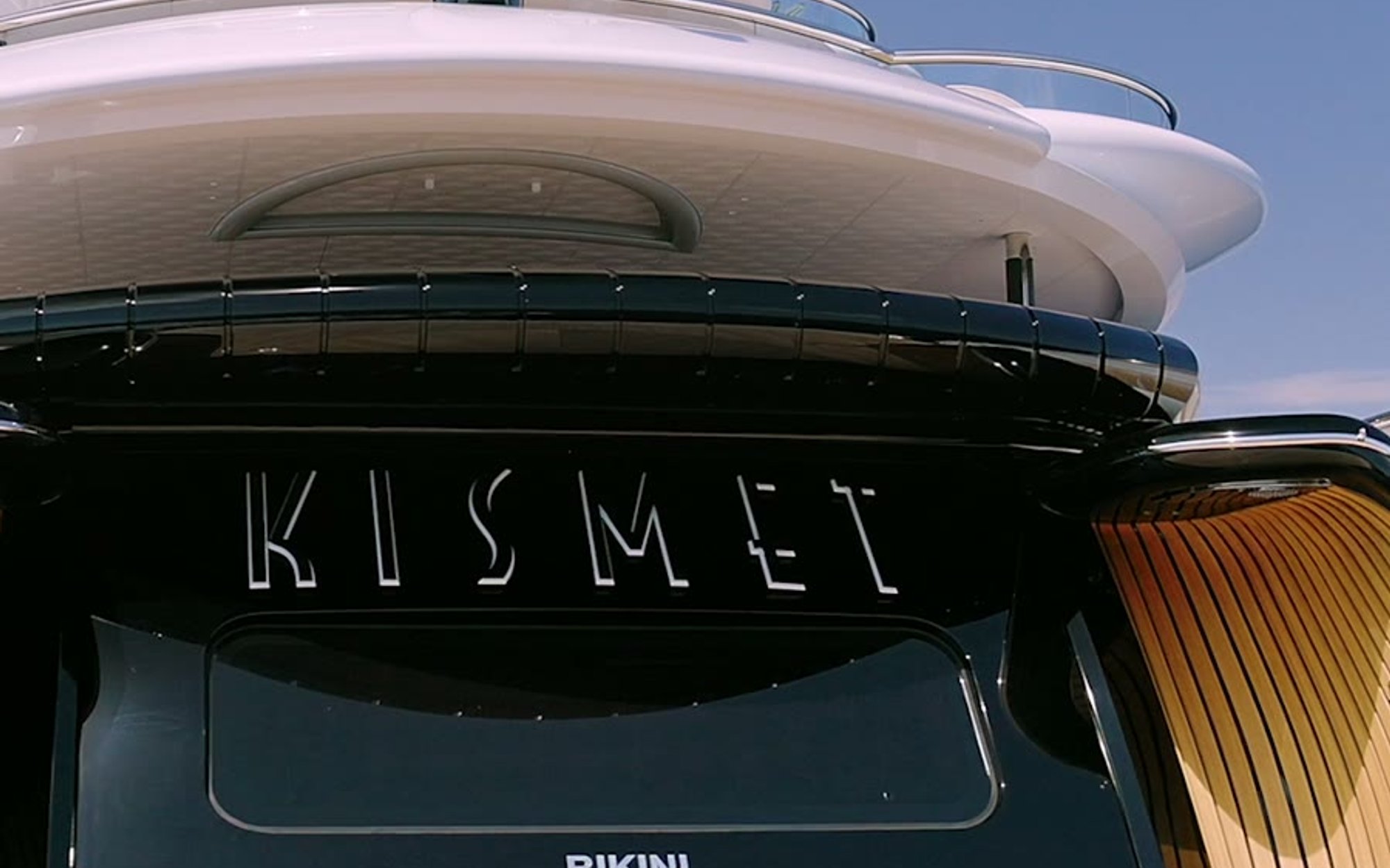Still from the Kismet reveal film, the yacht's stern and Marshall Islands flag from the water