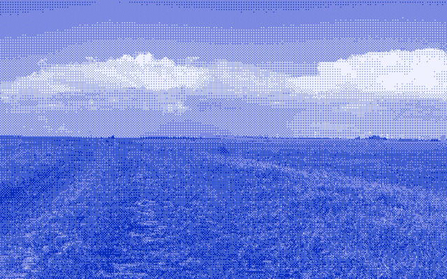 A bank of storm cloud spread across the sky above a dark, open field.