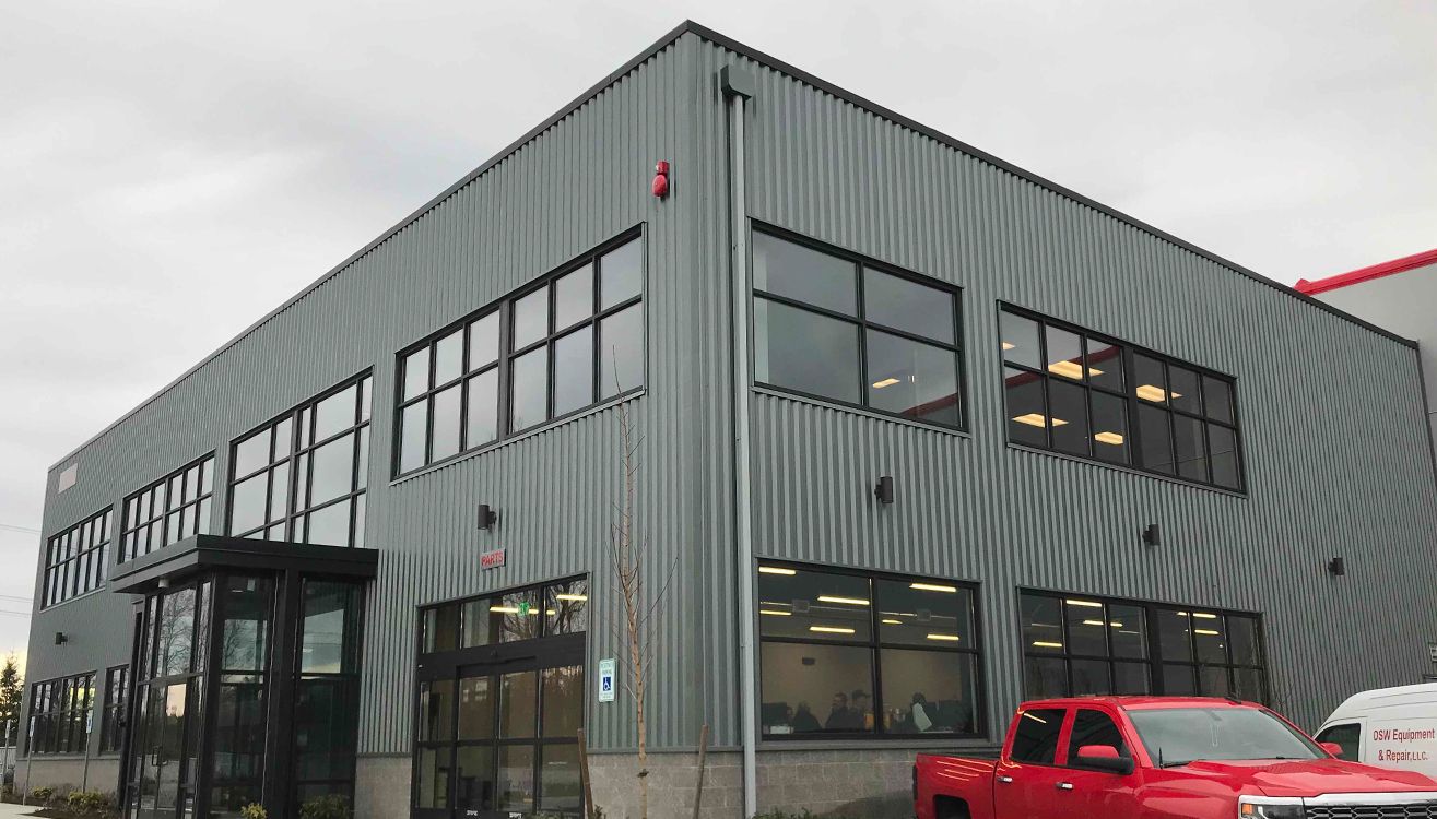 Completed office entrance with metal siding and two stories of windows.
