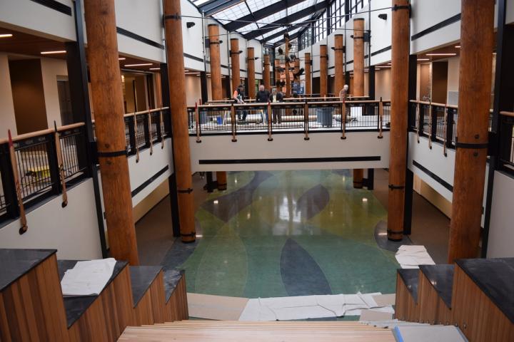 Atrium near completion, with turned-log columns, paddle railings and river-patterned concrete floor