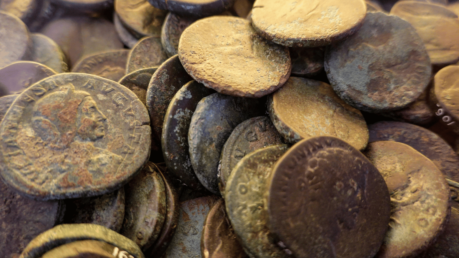 A hoard of ancient Roman coins, one stamped with a portrait