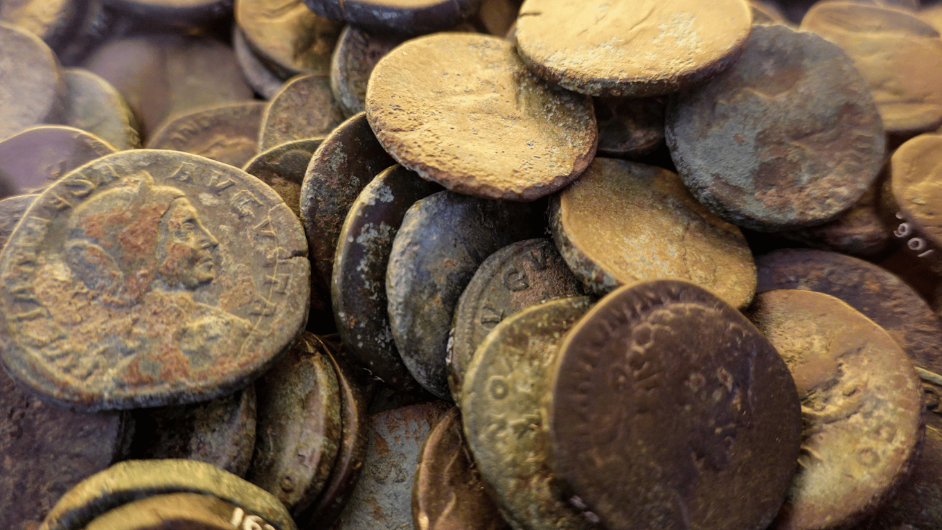 A hoard of ancient Roman coins, one stamped with a portrait