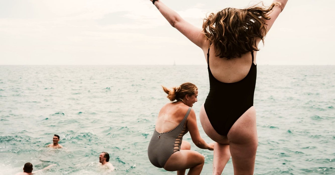 vrouw met corrigerend badpak springt in water