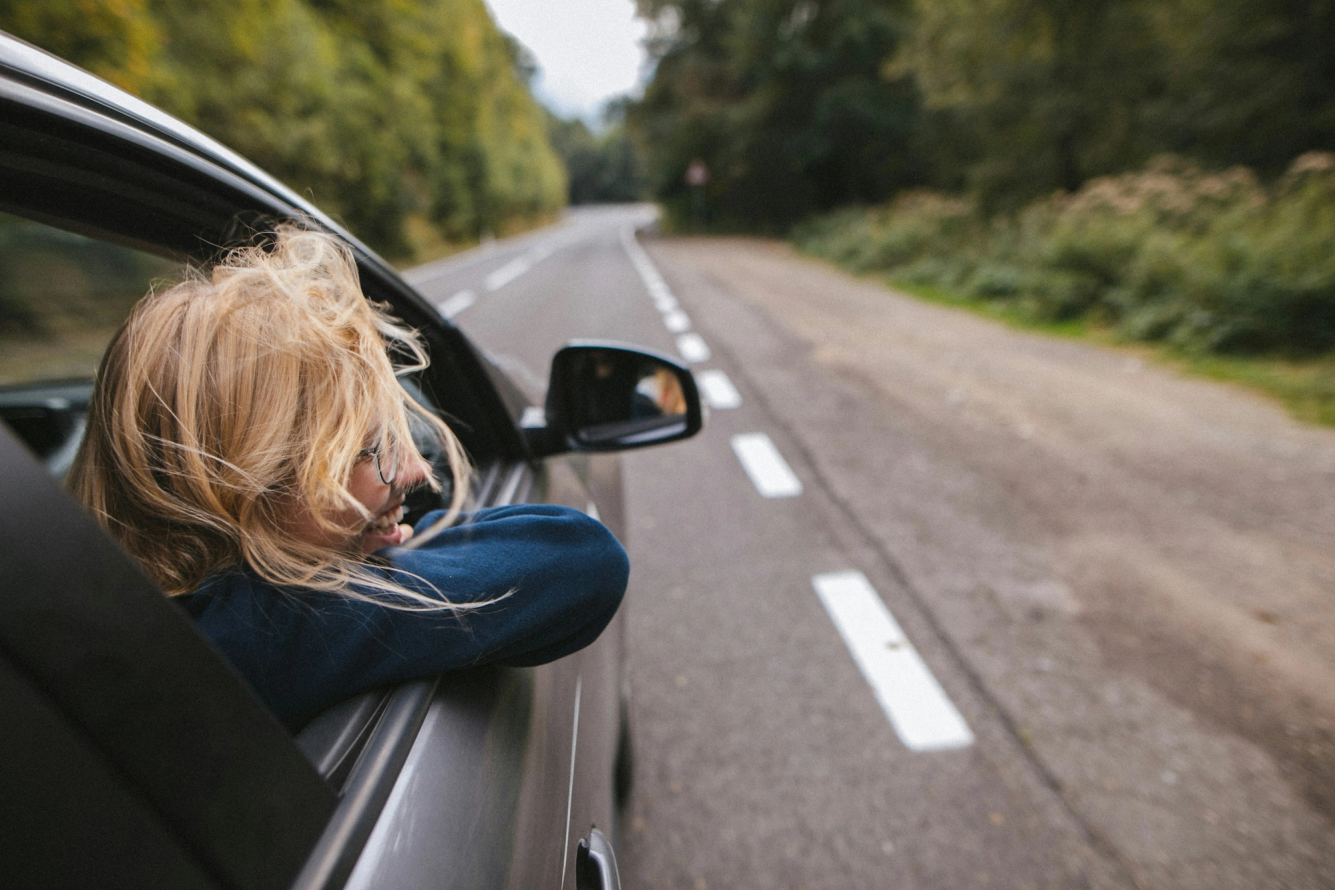 Kind in auto die uit het raam kijkt
