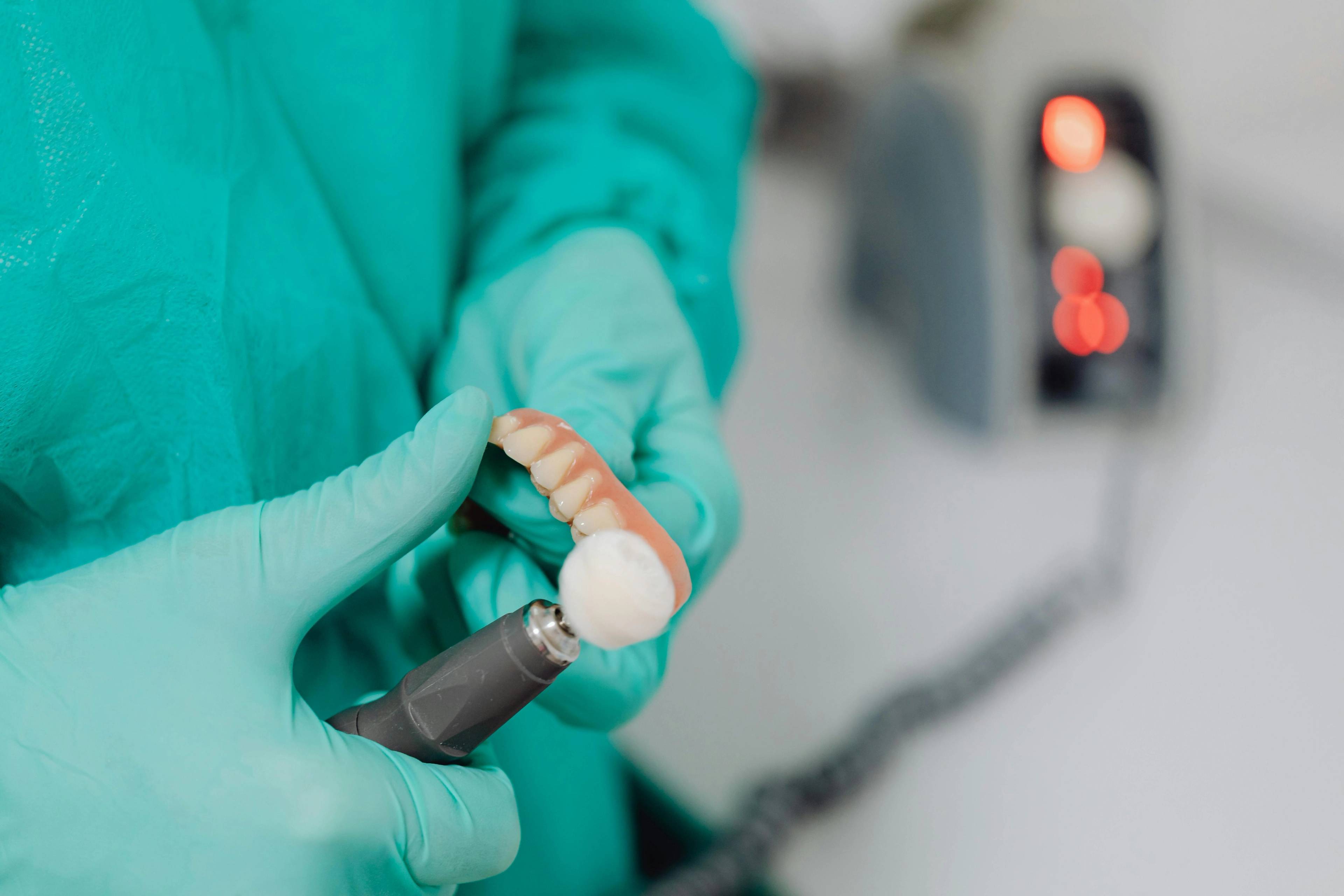 A stock photo of a dentist polishing a partial denture