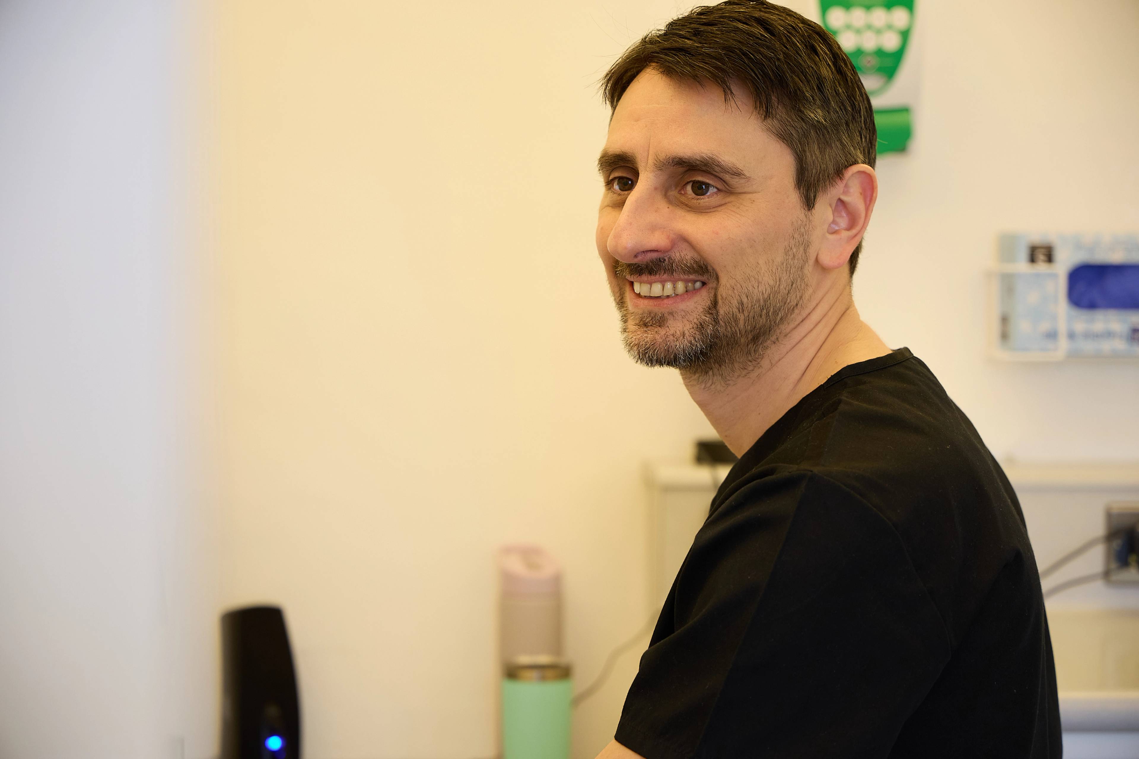 Oreste Gheorghe smiling in a staff area of the practice