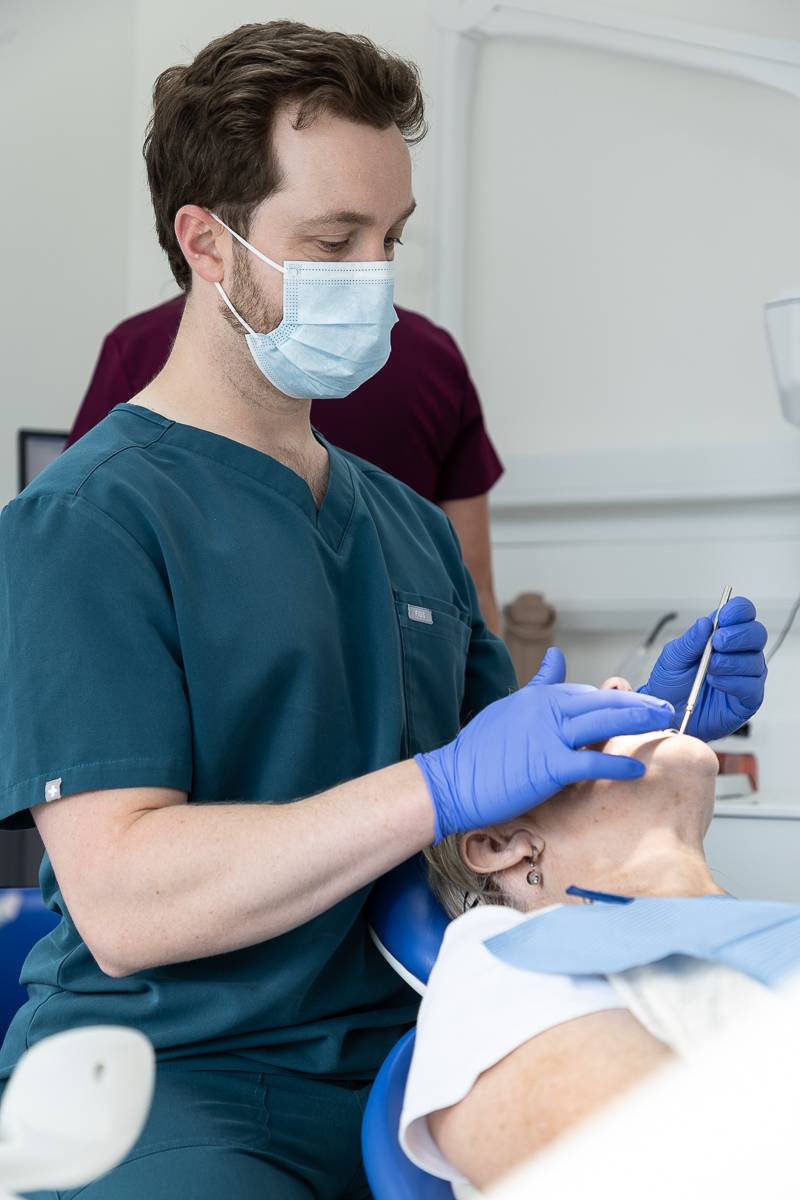 Tom Mann giving a patient a filling
