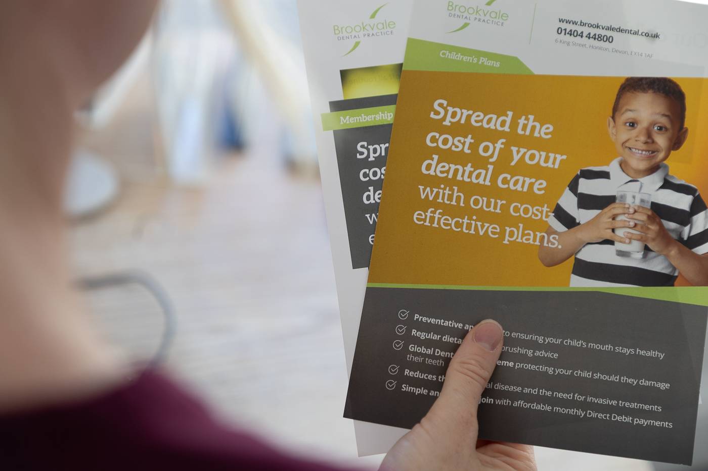 One of our nurses holding a membership plan leaflet