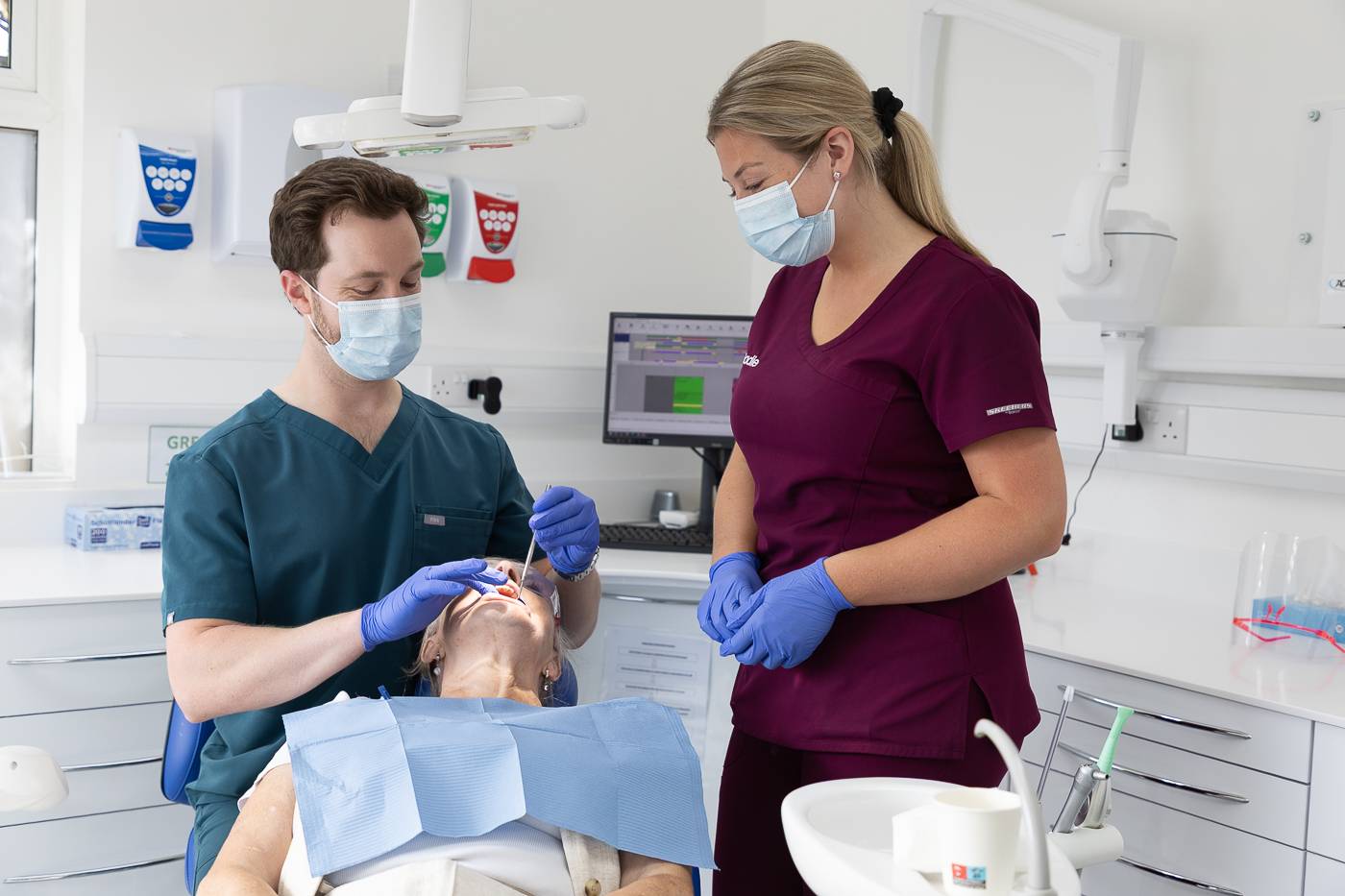 Tom Mann and dental nurse Sadie inspecting a patient's teeth
