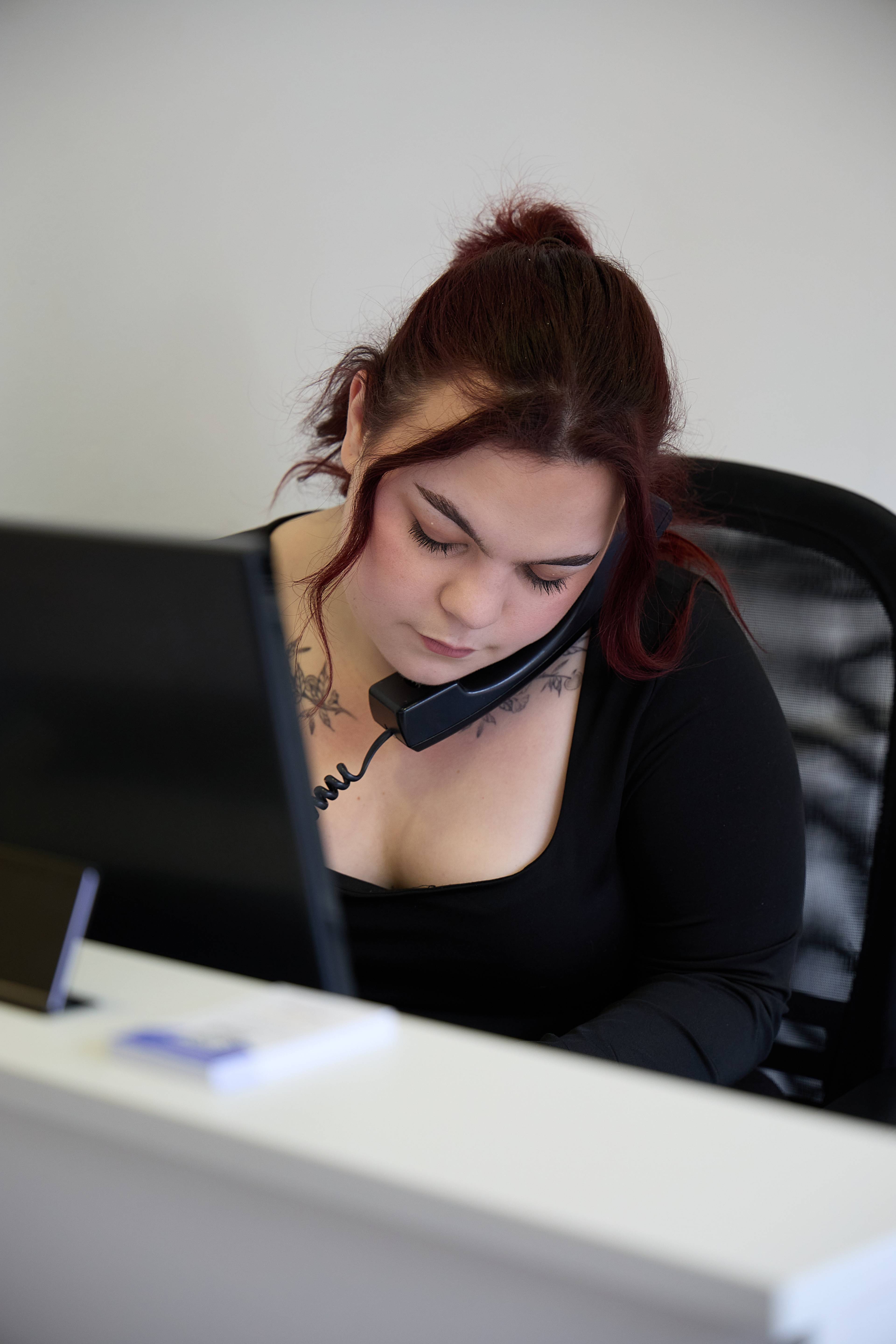 A receptionist at our team speaking on the phone at her front-of-house desk