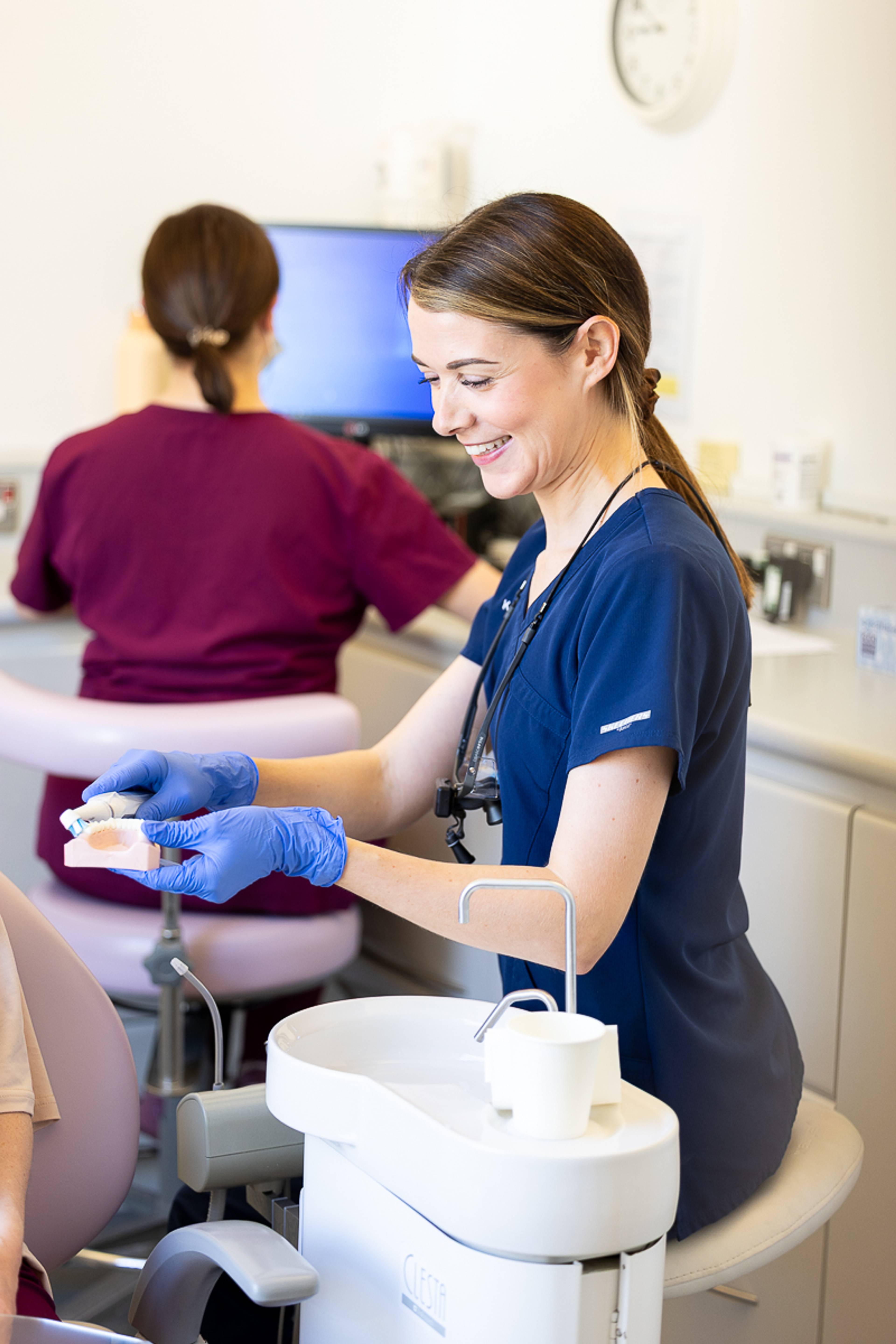 One of our hygienists demonstrating tooth care on a model of teeth