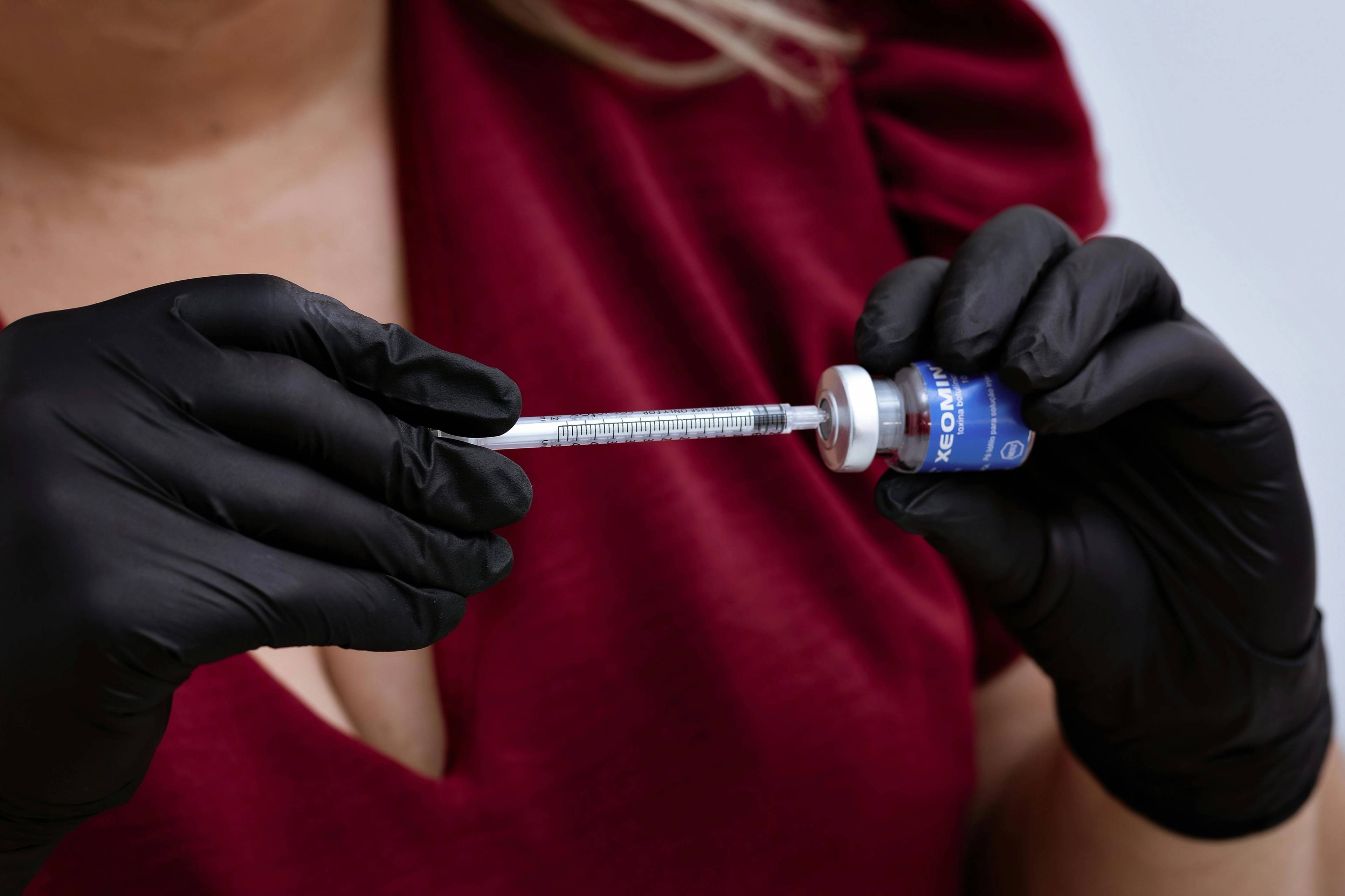 A stock photo of a woman filling a needle with botulinum toxin