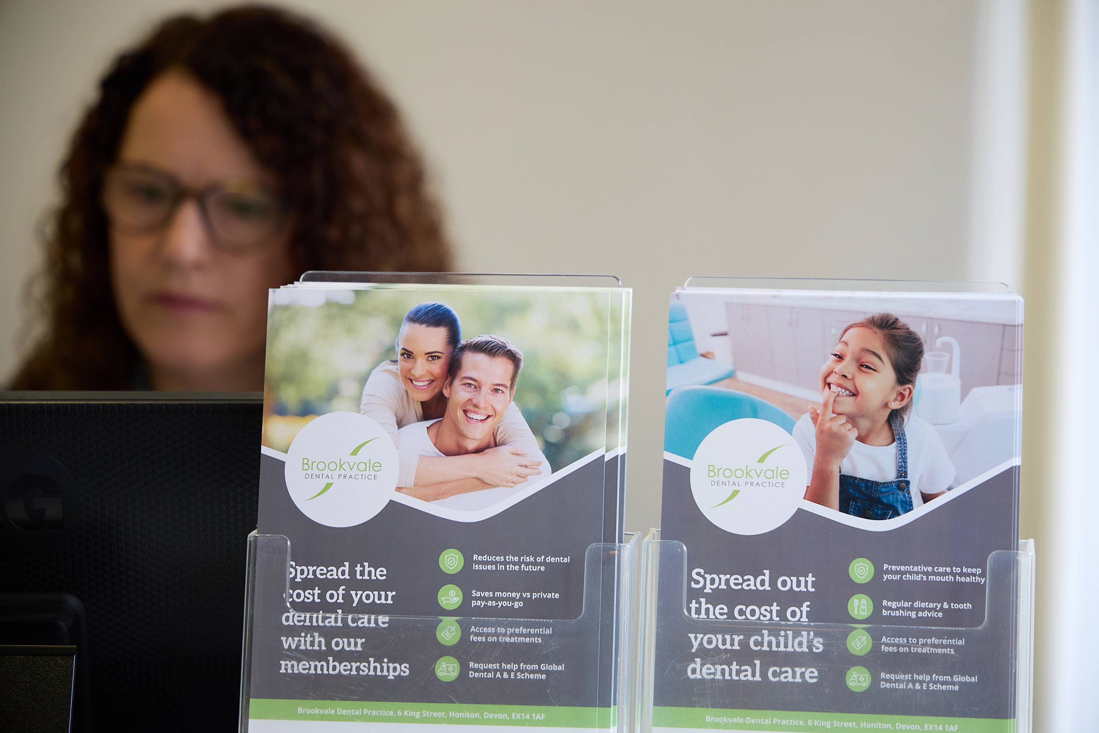 A member of our reception team sitting behind some of our leaflets