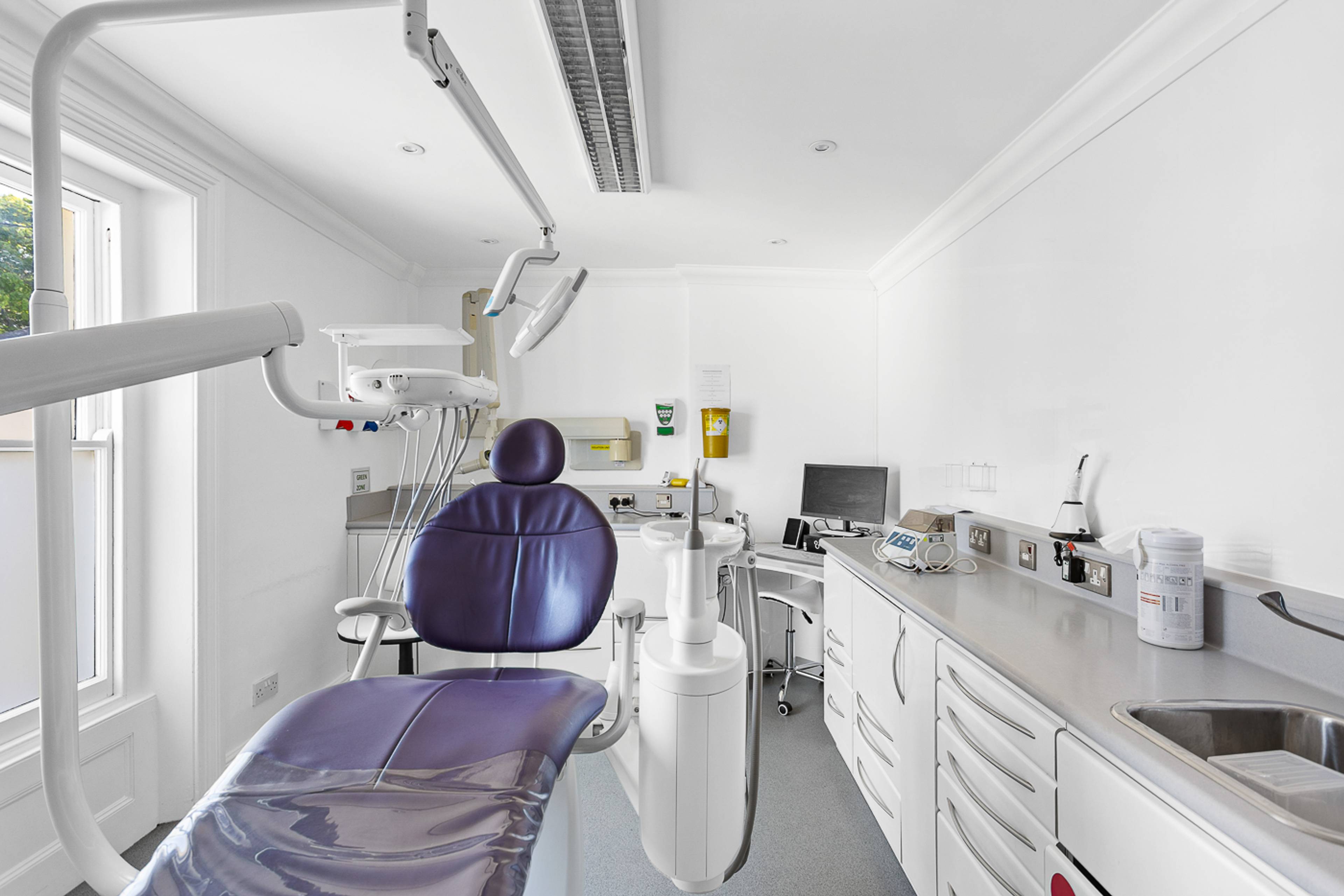 One of our treatment rooms with bright white walls and a purple chair