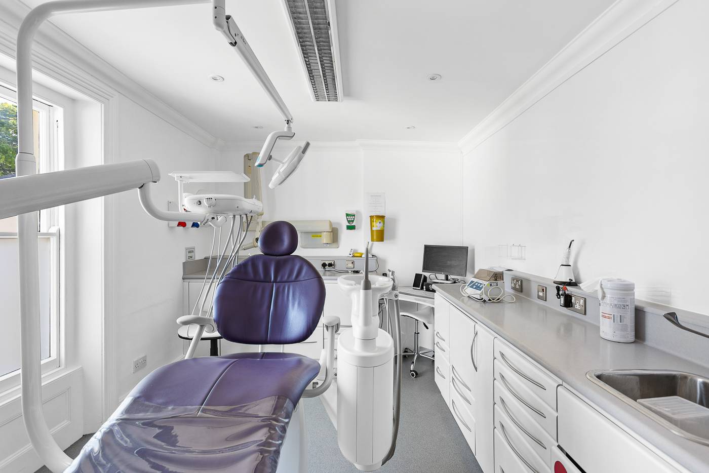 One of our treatment rooms with bright white walls and a purple chair