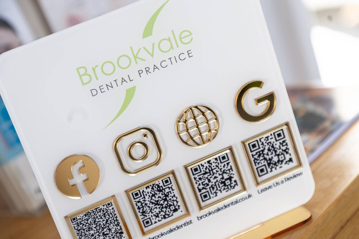 A sign at the front of Brookvale Dental Practice with social media icons
