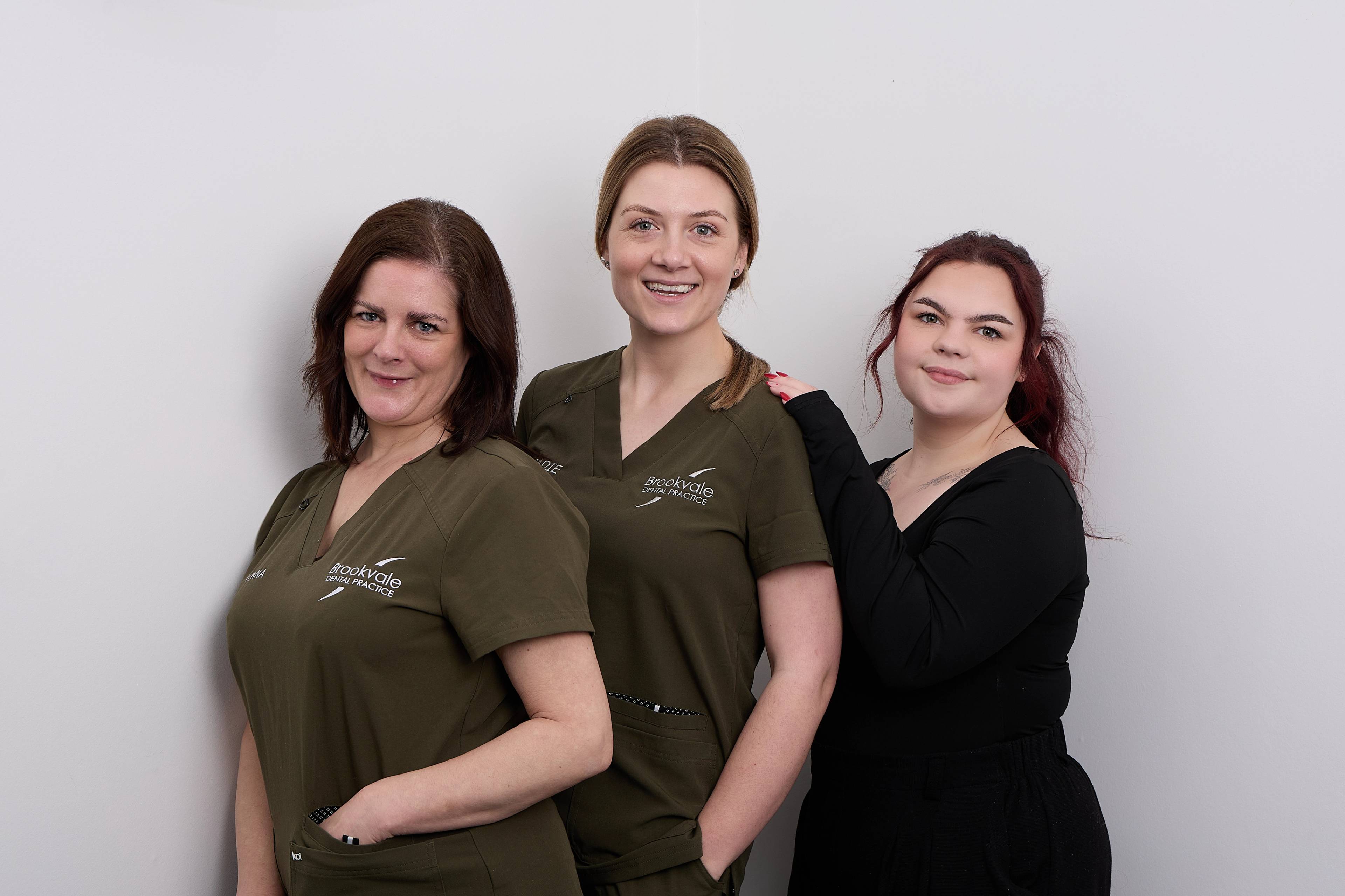 Rachel Patten and two members of her team smiling in front of a white background