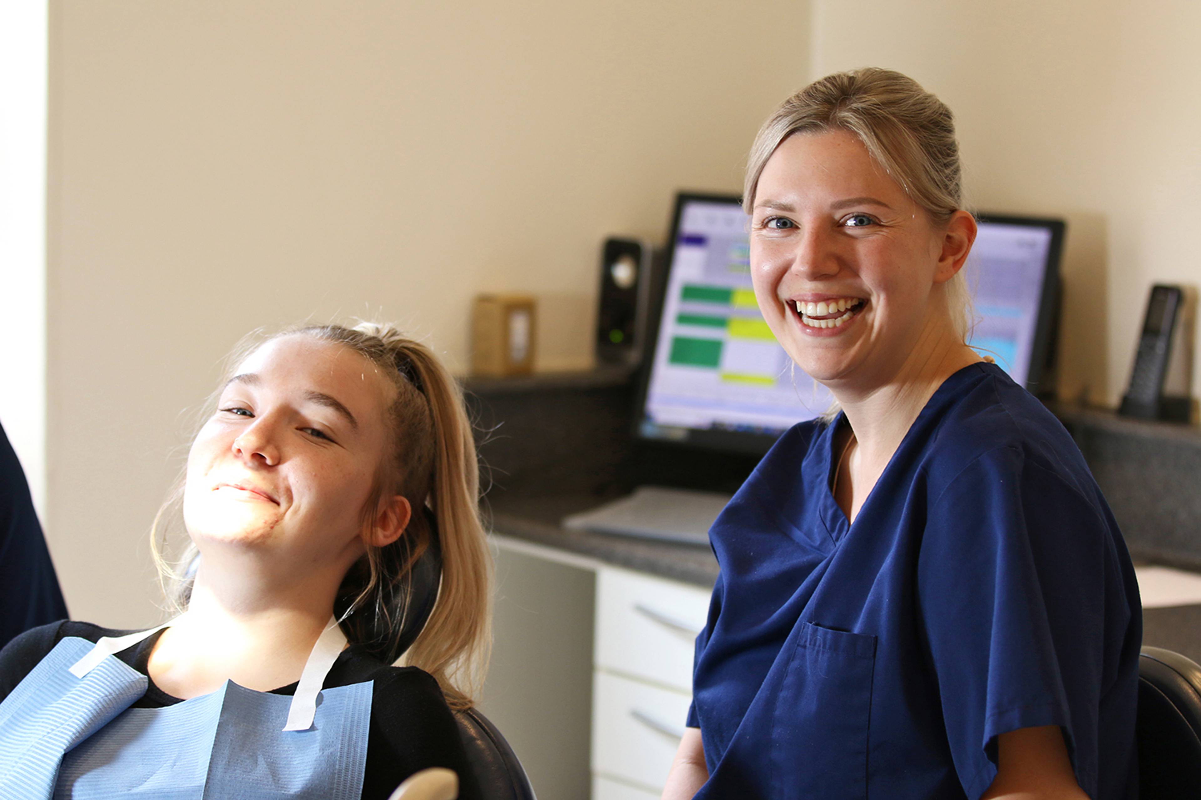 One of the members of the Merrifield team with a patient who is sitting in the chair