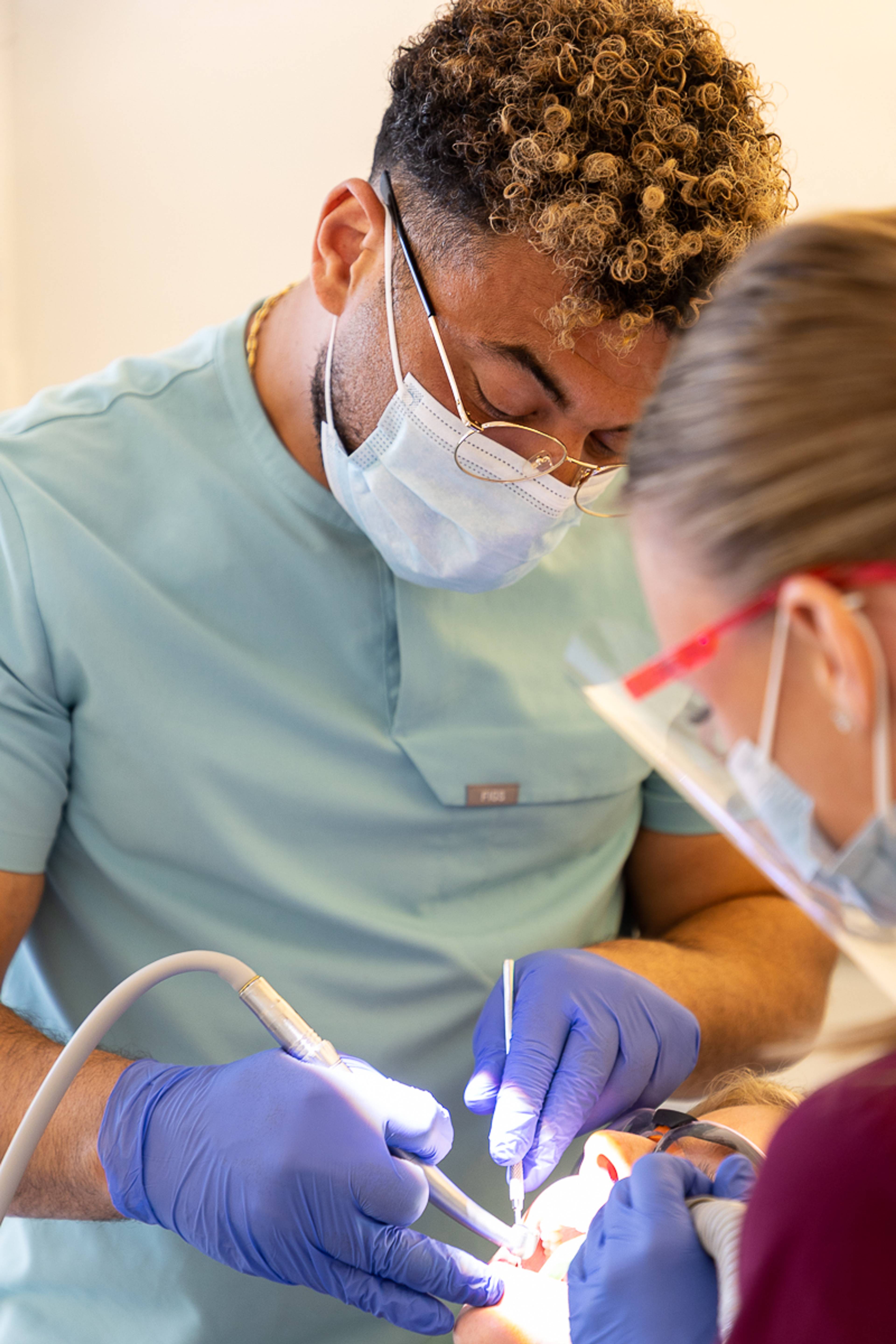 A dentist and a dental nurse working on a patient