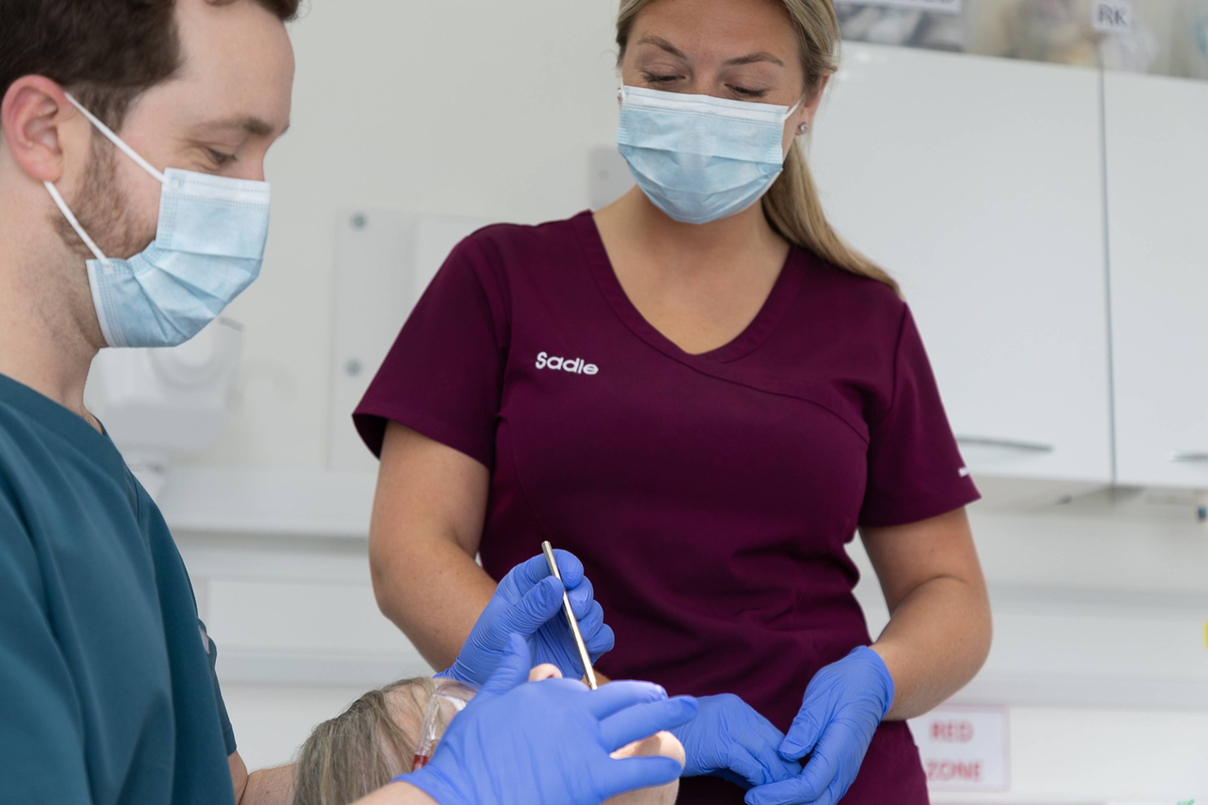 Tom Mann and nurse Sadie examining a patient's teeth