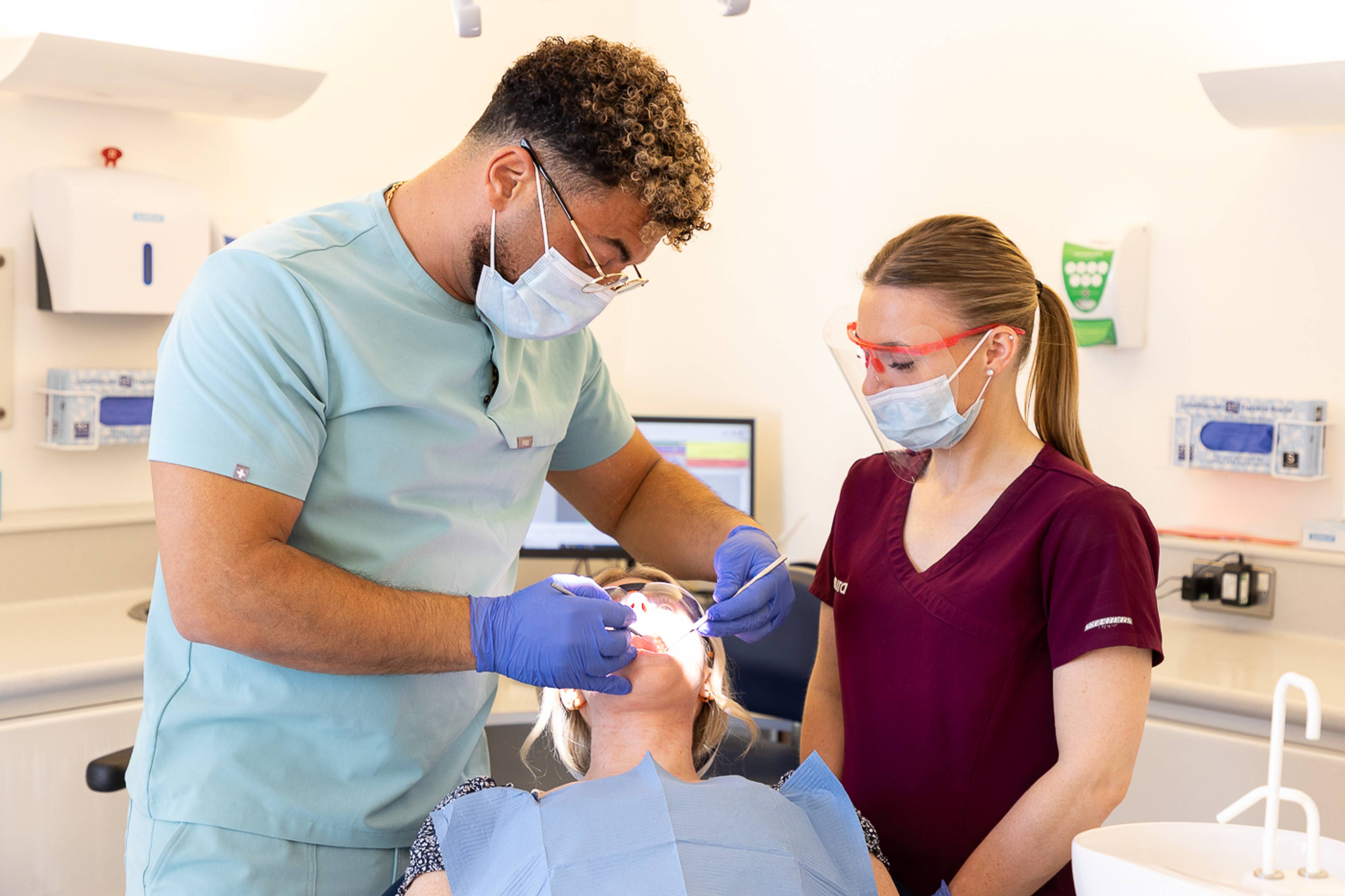 Tariq Abolsoud inspecting a patient's teeth