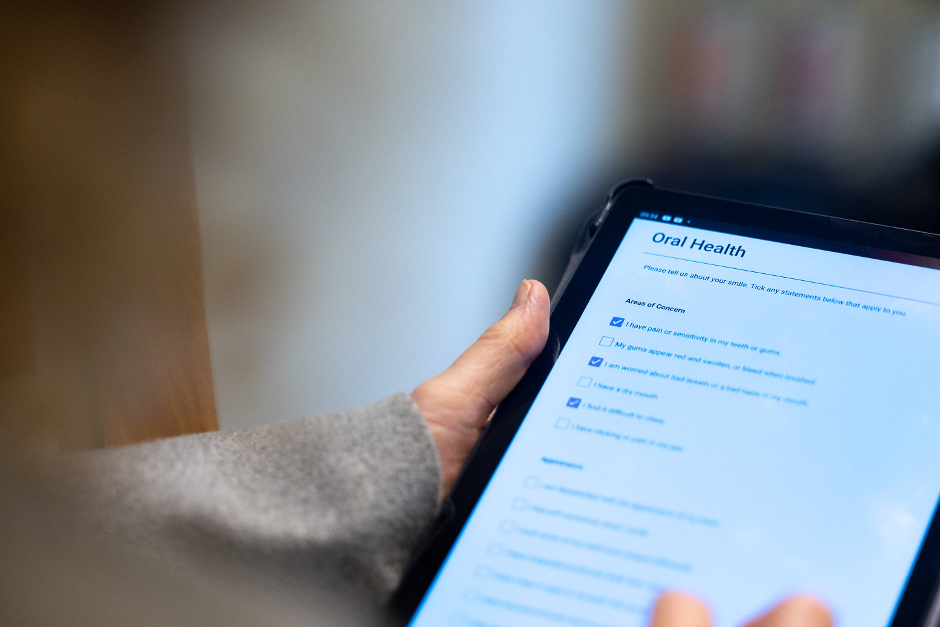 Close up of patient holding an i pad to complete clinical forms