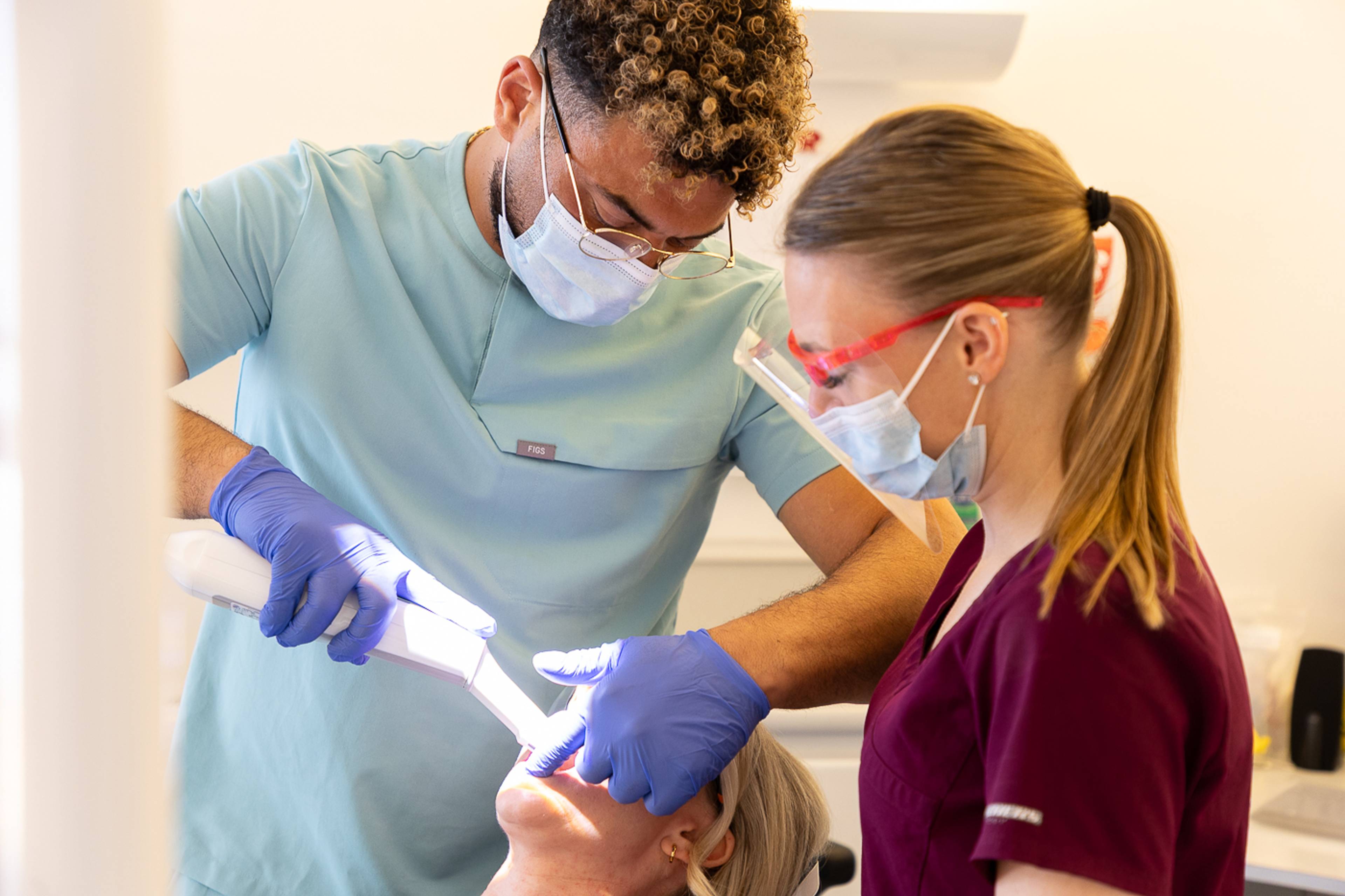 Tariq and Sadie scan a patient's mouth using the intraoral scanner